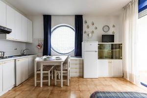a kitchen with white cabinets and a table and a window at Apartment in Bibione near tennis court in Bibione