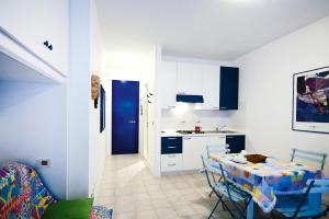 a kitchen with a table and a kitchen with blue cabinets at Apartment in Bibione near tennis court in Bibione