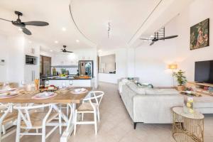 sala de estar con mesa y sofá en Marina View - Waterfront Stunner with Plunge Pool, en Darwin