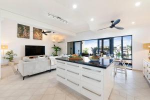uma cozinha e sala de estar com um sofá e uma mesa em Marina View - Waterfront Stunner with Plunge Pool em Darwin