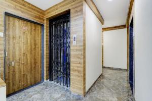a door in a room with wooden walls at OYO Hotel Signature in Ahmedabad