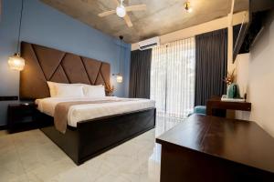 Limeshine - Airport Transit Hotel في كاتوناياكى: غرفة نوم بسرير كبير مع مروحة سقف