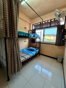 a room with two bunk beds and a window at Karma Home Hostel in Phitsanulok