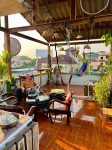 a man sitting in a living room with a hammock at Karma Home Hostel in Phitsanulok