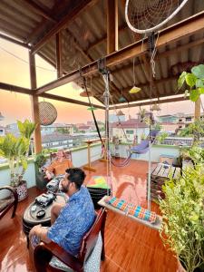 Due uomini seduti in un soggiorno con sedie di Karma Home Hostel a Phitsanulok
