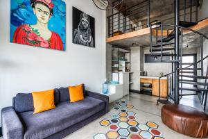 a living room with a couch and a staircase at Balissimo Apartment by Hombali in Seminyak