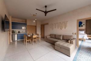 een woonkamer en een keuken met een bank en een tafel bij Suite 2 camas y sofa cama in Mexico-Stad