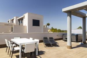 d'une terrasse sur le toit avec une table blanche et des chaises. dans l'établissement Top floor Pink Vistagolf - Winter by the sea, à San Miguel de Salinas