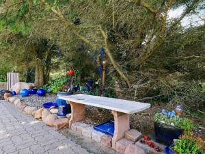 8 person holiday home in Harbo re في هاربور: طاولة نزهة خشبية في حديقة بها نباتات