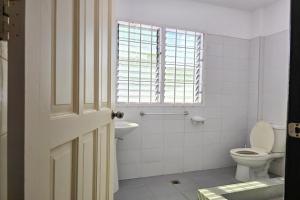 a bathroom with a toilet and a sink and a window at Surfside Hostel in San Juan