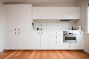 Kings ParkModern Self Contained Unit Views Parking and WiFi的白色的厨房配有白色家电,铺有木地板 更多8张照片