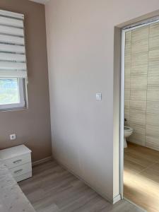 een slaapkamer met een deur naar een badkamer bij Вила in Asprovalta