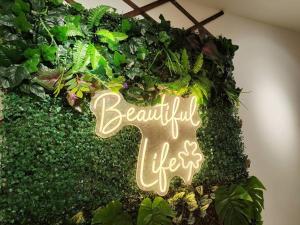 a sign that says beautiful sign on a green wall at Petaling Jaya Landed Home for up to 15pax, 4BedRoom at Damansara , 1 Utama , Starling Mall , Atria Mall, IKEA in Petaling Jaya