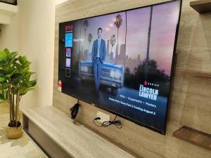 uma televisão de ecrã plano sentada numa parede em Petaling Jaya Landed Home for up to 15pax, 4BedRoom at Damansara , 1 Utama , Starling Mall , Atria Mall, IKEA em Petaling Jaya