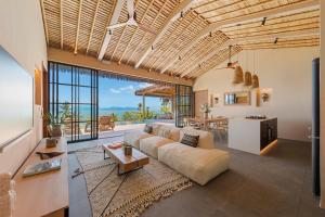 a living room with a couch and a table at Wabi Sabi Tropical Seaview Villa in Mae Nam