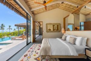 a bedroom in a villa with a bed and a pool at Wabi Sabi Tropical Seaview Villa in Mae Nam