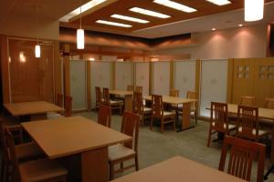 une salle à manger avec des tables, des chaises et des casiers dans l'établissement Kusatsu Estopia Hotel, à Kusatsu