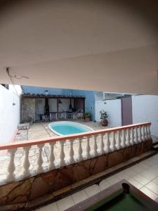 uma casa com uma piscina e uma cerca branca em Maré Alta Hostel em Ubatuba