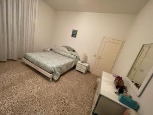 ein Schlafzimmer mit einem Bett, einem Spiegel und einer Kommode in der Unterkunft Rimini Holiday Apartment in Rimini