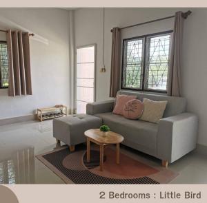 salon z kanapą i stołem w obiekcie Betong House in the Garden w mieście Betong