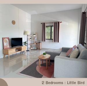 uma sala de estar com um sofá e uma televisão em Betong House in the Garden em Betong