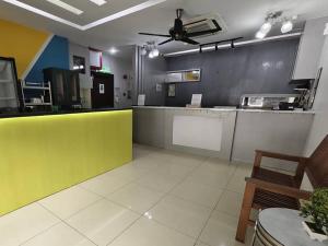 a restaurant kitchen with a yellow and white counter at Mozu Hotel Sri Hartamas in Kuala Lumpur