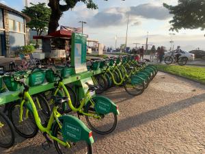 uma fila de bicicletas verdes estacionadas num passeio em Apartamento em Santos na Ponta da Praia em Santos