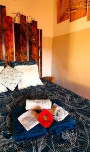 a bed with towels and a red flower on it at UNE PAUSE EN FORET A LA FERME in Bormes-les-Mimosas