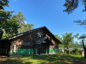 Irori 新山ふるさと体験館 في إينا: منزل به سقف مقامر وتقليم أخضر