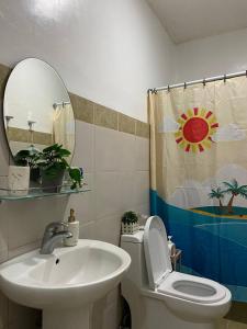 uma casa de banho com um lavatório, um WC e um espelho. em CamiStays Homestay in Camiguin, Best for Groups or Family em Mambajao