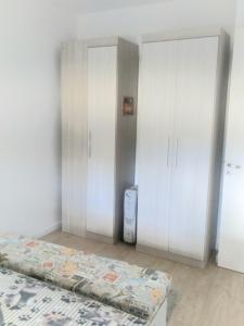 a bedroom with a bed and a washer and dryer at Apartamento na Serra Gaúcha in Caxias do Sul