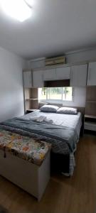 um quarto com uma cama grande e uma janela em Apartamento na Serra Gaúcha em Caxias do Sul