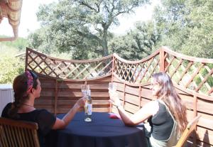 dos mujeres sentadas en una mesa en un patio en UNE PAUSE EN FORET A LA FERME, en Bormes-les-Mimosas