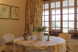 a table with a white table cloth and candles and a window at Silo Cottage in Underberg