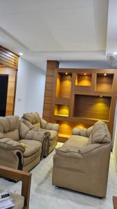 a living room with couches and a flat screen tv at LMR Stays and Holidays in Trichūr