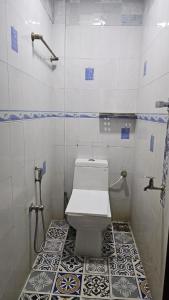 a bathroom with a toilet and a tiled floor at LMR Stays and Holidays in Trichūr