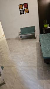 a room with a green bench sitting on a tile floor at LMR Stays and Holidays in Trichūr