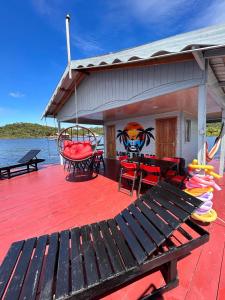 a deck with a table and chairs on a boat at Casa flutuante - Manaus Amazonas in Manaus