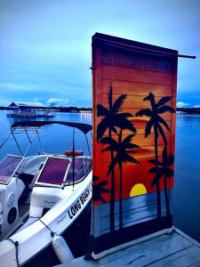 ein Boot, das an einem Dock mit einem Gemälde von Palmen parkt in der Unterkunft Casa flutuante - Manaus Amazonas in Manaus