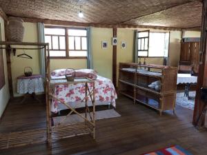 a bedroom with a bed and a dresser and windows at Fazenda Mundo Novo in Divisa