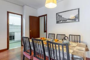 a dining room with a table with chairs and a kitchen at AB Passeig de Gràcia Còrsega in Barcelona