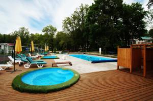 a swimming pool with a wooden deck and a swimming poolvisor at Dubrava Park-Hotel in Samara