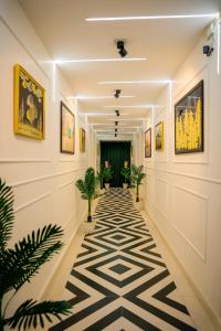 um corredor com plantas e pinturas nas paredes em Agrah Stay - Kasa Lusso Stay em Faridabad