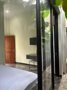 een slaapkamer met een bed en een bank in een kamer bij Nofrah House Syariah Mitra RedDoorz in Tjolomadu