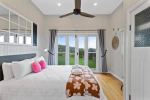 1 dormitorio con 1 cama grande con almohadas rosas en The Quince Cottage - 2 Bedrooms, en Ravensbourne
