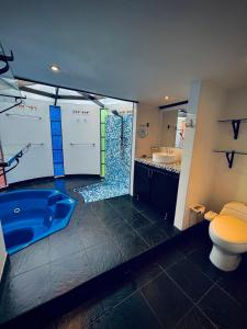 uma casa de banho com uma banheira azul e um WC. em Hotel Oh My Dog em Medellín