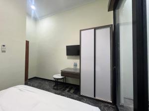 een slaapkamer met een spiegel, een bed en een bureau bij Nofrah House Syariah Mitra RedDoorz in Tjolomadu