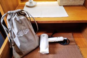 una bolsa y un secador de pelo junto a una mesa en Ayla Chalet en Phrae