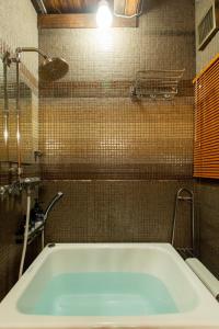 a bath tub in a bathroom with a tiled wall at Shinagawa-ku - House / Vacation STAY 12126 in Tokyo