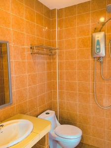 uma casa de banho com um WC, um lavatório e um chuveiro em Amzar Motel Cenang em Pantai Cenang